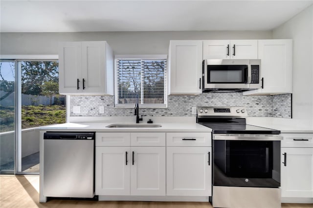 kitchen featuring appliances with stainless steel finishes, white cabinetry, and sink