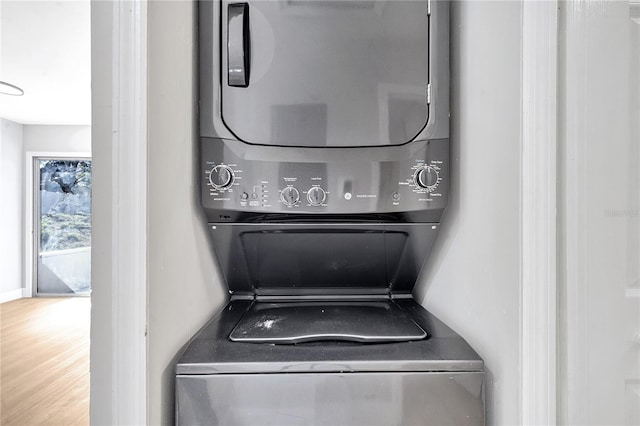 washroom featuring stacked washer and dryer and hardwood / wood-style flooring