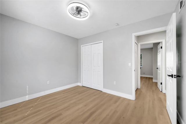 unfurnished bedroom with a closet and light wood-type flooring