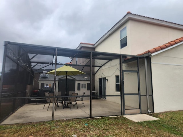 rear view of property featuring a patio and a lanai