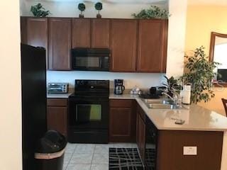 kitchen featuring kitchen peninsula, sink, light tile patterned floors, and black appliances