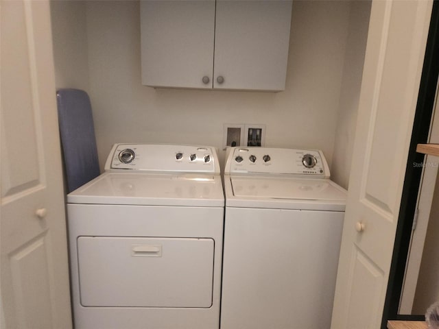 laundry area featuring washer and dryer and cabinets