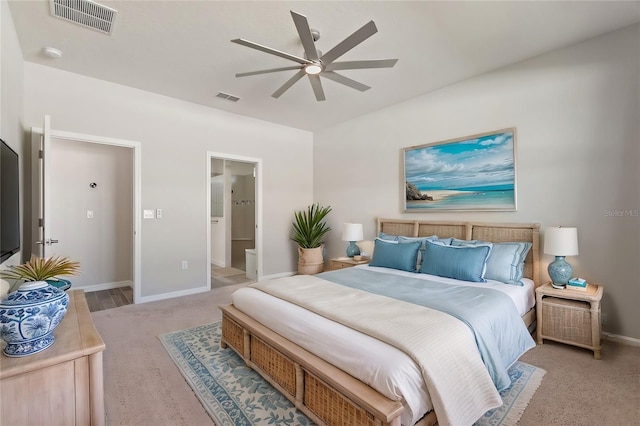 bedroom featuring ceiling fan, light carpet, and ensuite bath