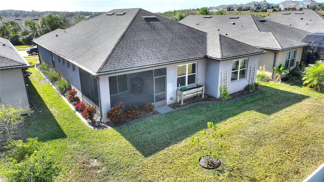 back of house featuring a sunroom and a lawn