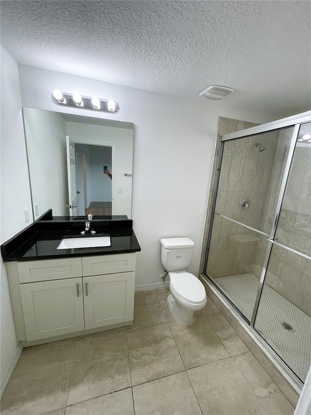 bathroom with walk in shower, vanity, a textured ceiling, and toilet