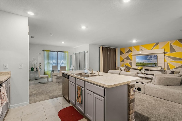 kitchen featuring dishwasher, sink, gray cabinets, light carpet, and a center island with sink