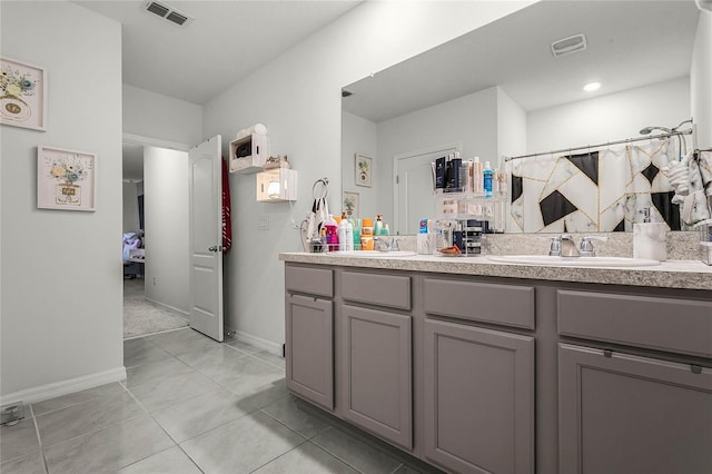 bathroom featuring tile patterned flooring, vanity, and curtained shower