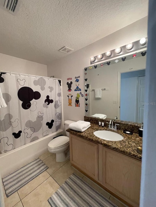 full bathroom with tile patterned floors, a textured ceiling, toilet, vanity, and shower / tub combo