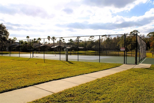 view of tennis court with a yard