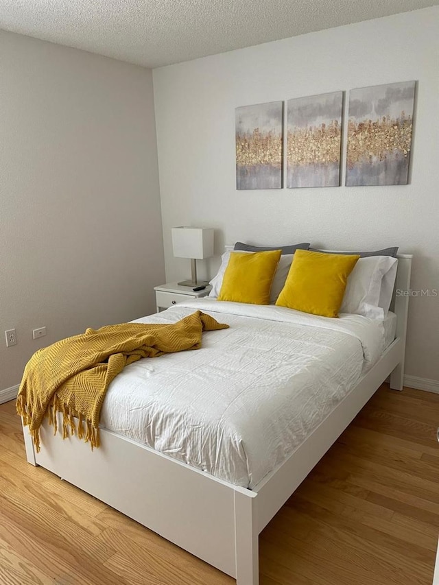 bedroom featuring hardwood / wood-style flooring and a textured ceiling