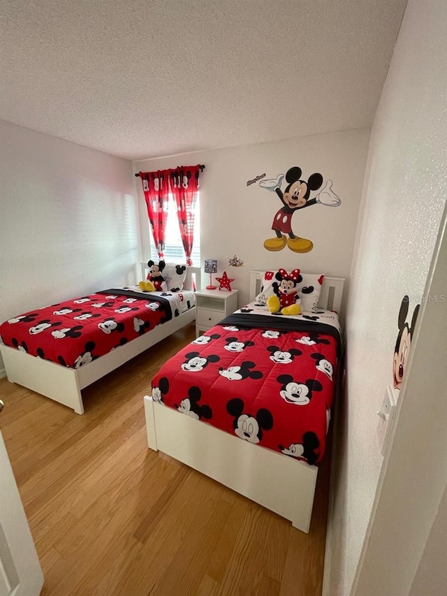 bedroom featuring hardwood / wood-style floors and a textured ceiling