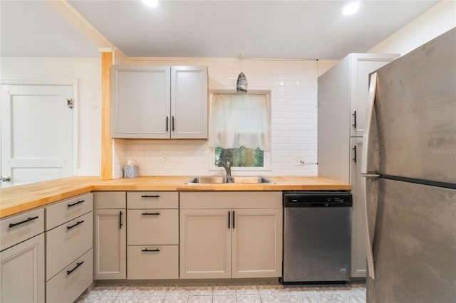 kitchen featuring sink, backsplash, butcher block counters, and stainless steel appliances