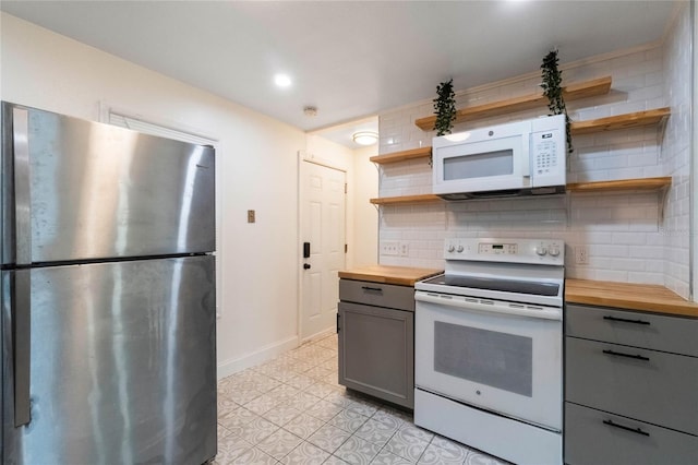 kitchen featuring gray cabinets, butcher block counters, backsplash, and white appliances