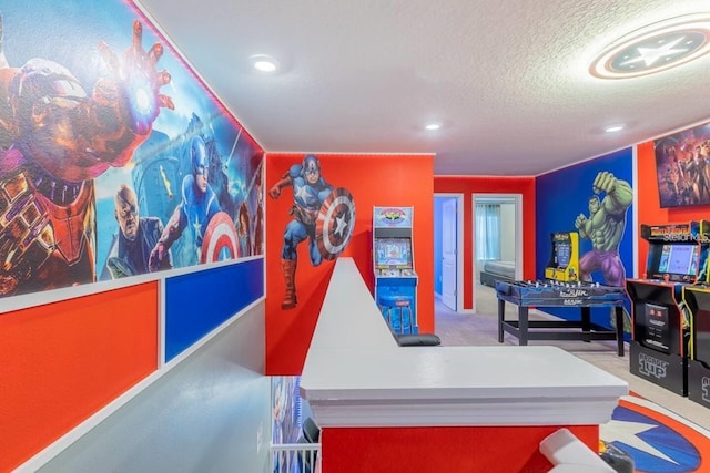 recreation room with a textured ceiling and carpet flooring