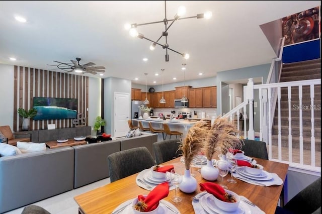 dining space with ceiling fan with notable chandelier