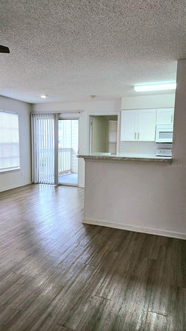 unfurnished living room with dark hardwood / wood-style floors and a textured ceiling