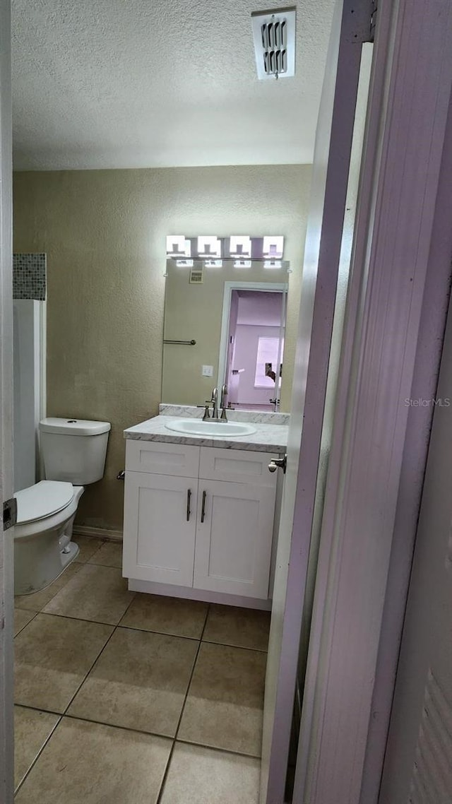 bathroom with tile patterned floors, vanity, and toilet