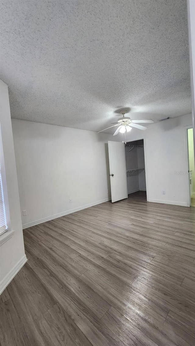 unfurnished room with hardwood / wood-style floors, ceiling fan, and a textured ceiling