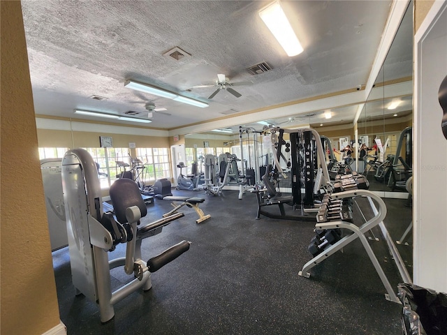 gym featuring ceiling fan and a textured ceiling