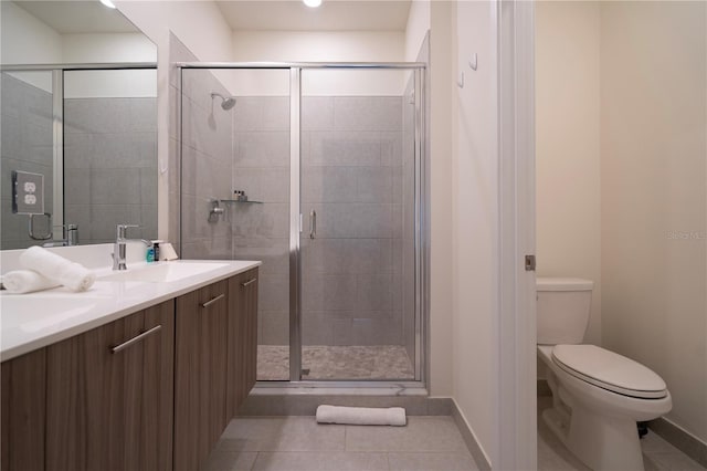 bathroom with tile patterned flooring, vanity, an enclosed shower, and toilet