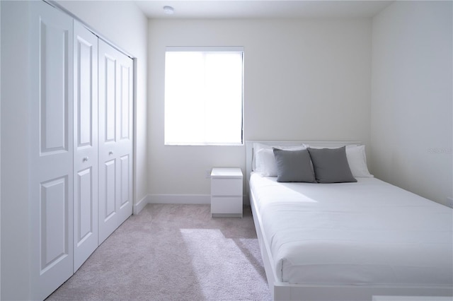 bedroom with light colored carpet and a closet