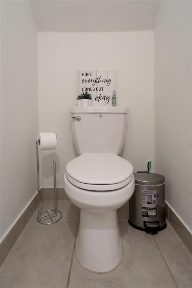 bathroom with tile patterned flooring, a textured ceiling, and toilet