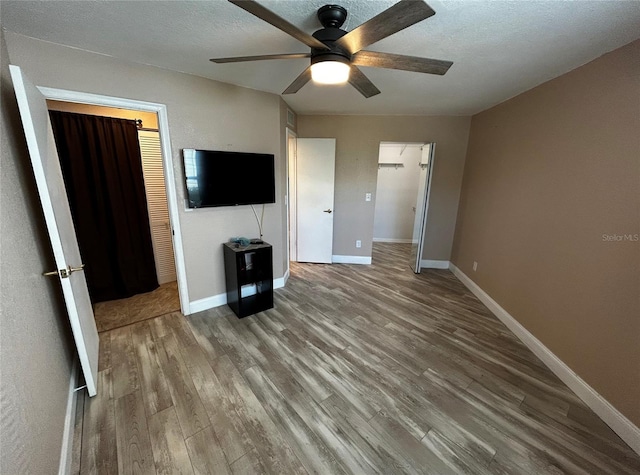 unfurnished bedroom with wood-type flooring, a closet, and ceiling fan