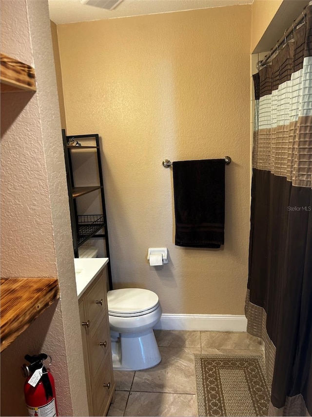 bathroom featuring tile patterned floors, vanity, and toilet