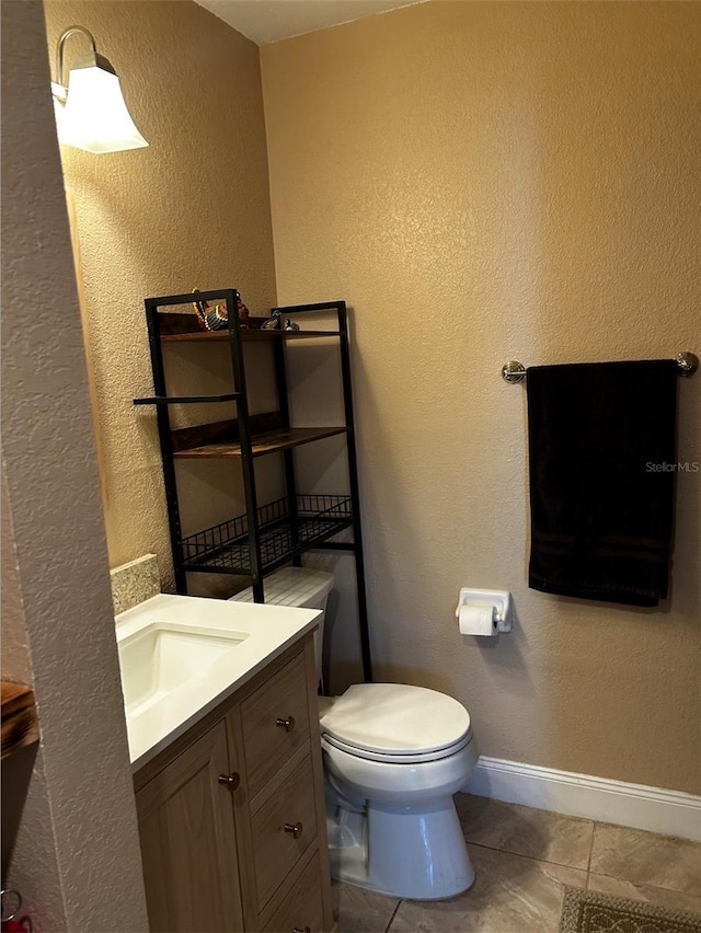 bathroom featuring tile patterned floors, vanity, and toilet