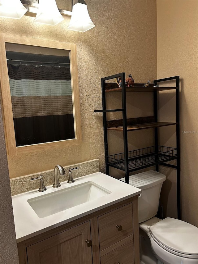 bathroom with vanity, toilet, and walk in shower