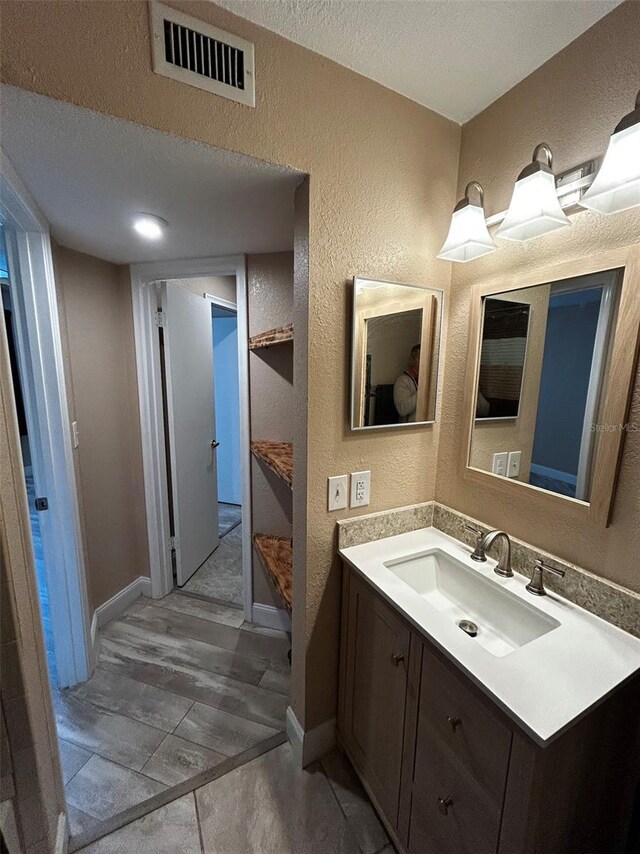 bathroom featuring tile patterned flooring, vanity, and a textured ceiling