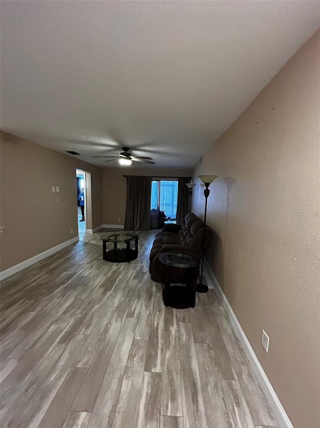 living room featuring light hardwood / wood-style flooring and ceiling fan