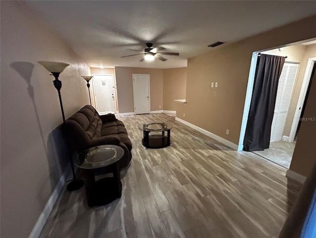 living room featuring ceiling fan and hardwood / wood-style flooring