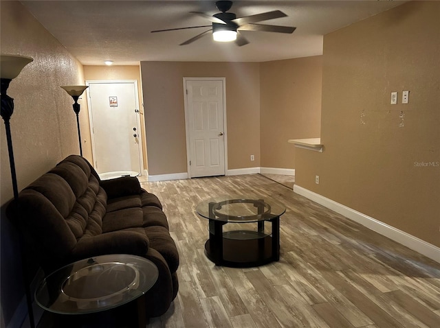 living room featuring wood-type flooring and ceiling fan