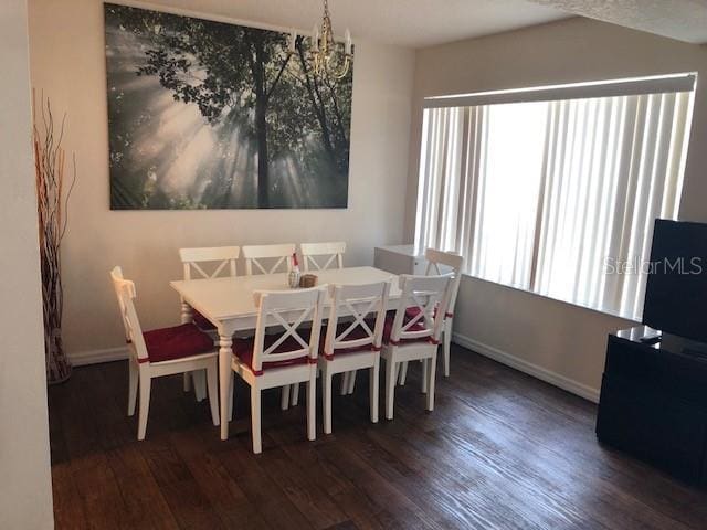 dining space featuring dark hardwood / wood-style floors and a notable chandelier