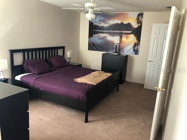 carpeted bedroom featuring a textured ceiling and ceiling fan