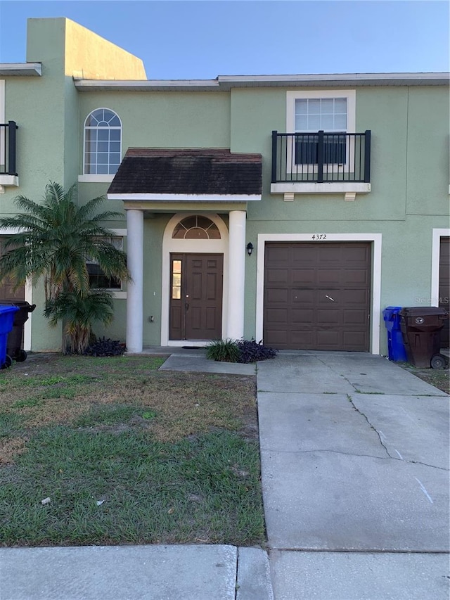 view of front of home with a garage and a balcony