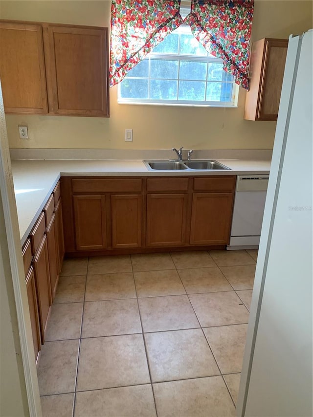 kitchen with dishwasher, light tile patterned floors, and sink