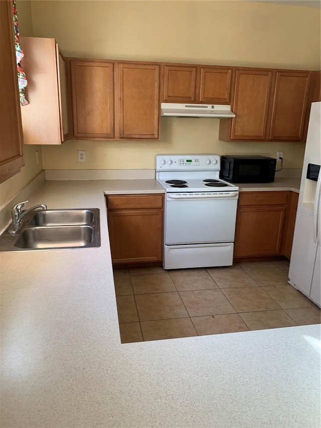 kitchen featuring white appliances, sink, and light tile patterned floors