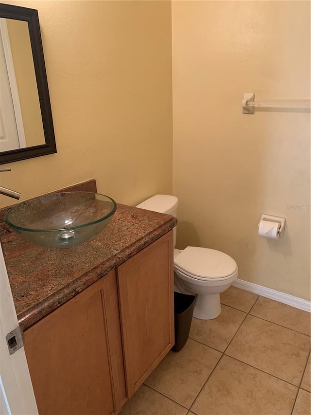 bathroom with tile patterned flooring, vanity, and toilet