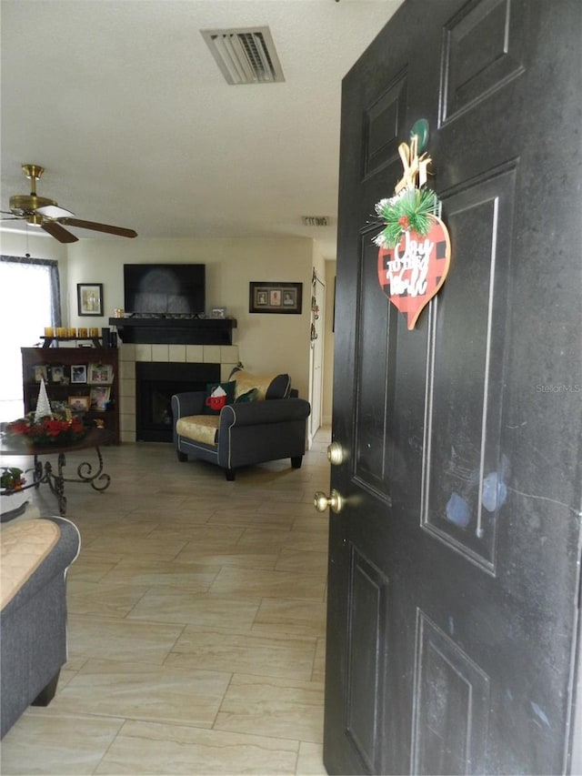 entryway featuring a fireplace and ceiling fan