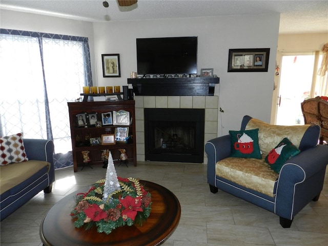 living room with ceiling fan and a fireplace