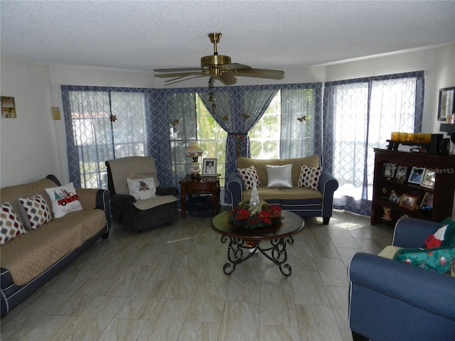 living room featuring a textured ceiling and ceiling fan