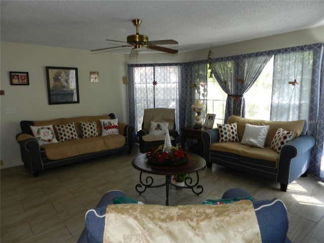 living room featuring ceiling fan, plenty of natural light, and a textured ceiling