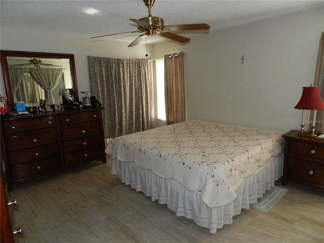 bedroom with ceiling fan and a textured ceiling