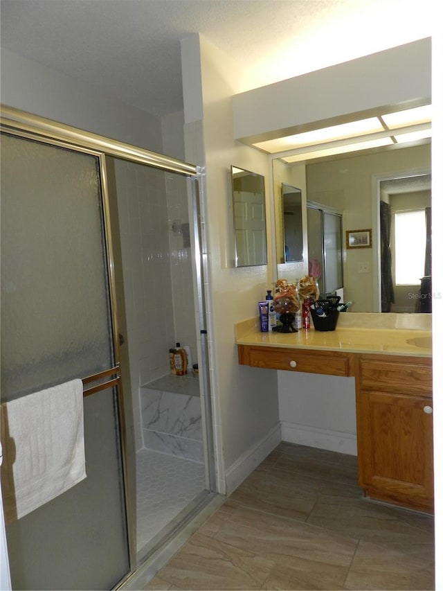 bathroom featuring vanity and a shower with door