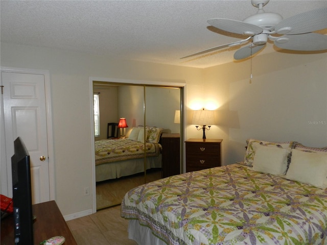 bedroom with ceiling fan, a textured ceiling, and a closet