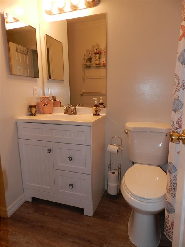 bathroom featuring wood-type flooring, vanity, and toilet