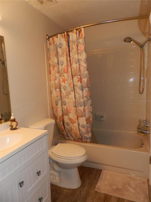 full bathroom with hardwood / wood-style floors, vanity, toilet, and shower / bath combo with shower curtain