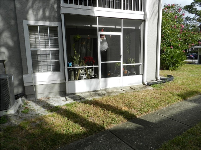 view of side of property with a sunroom, cooling unit, and a yard